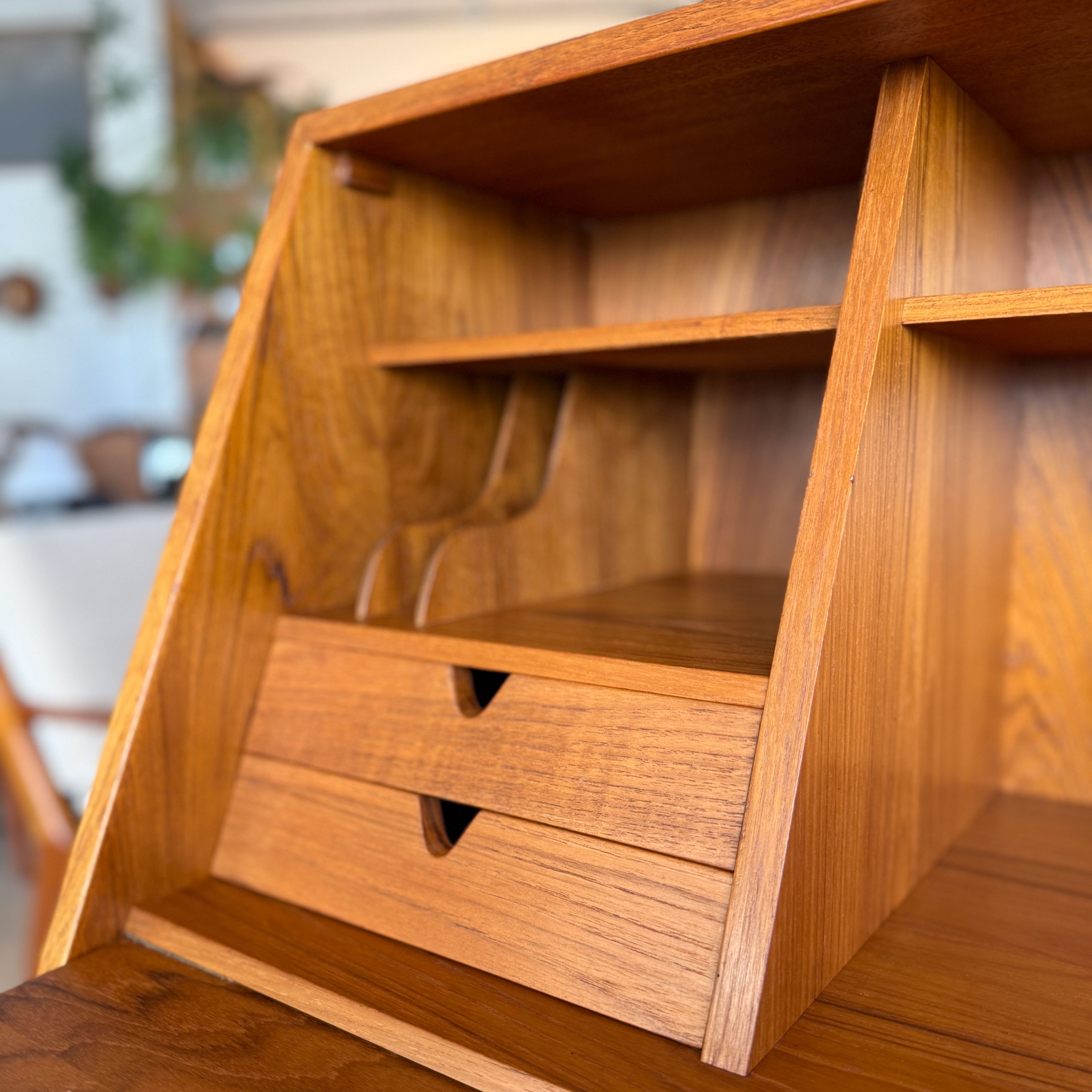Close-up view of a wooden desk organizer featuring shelves and two small drawers.