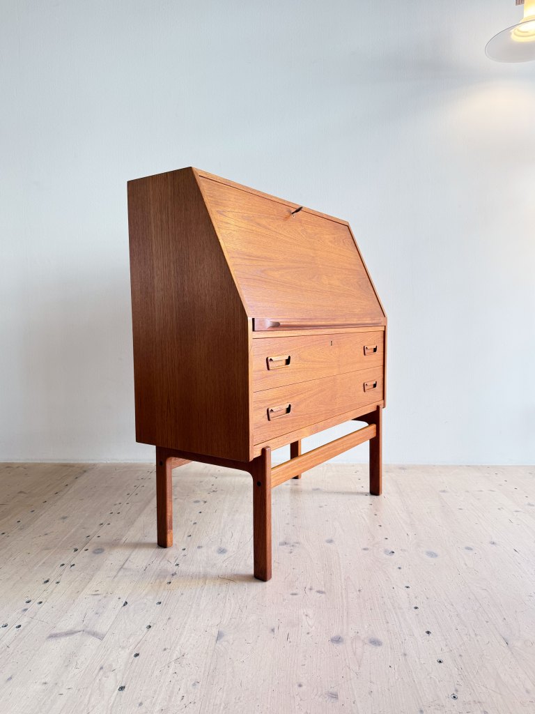 Elegant Danish mid-century teak secretary designed by Arne Wahl Iversen, featuring a drop-front writing surface, practical compartments, and spacious lower drawers.