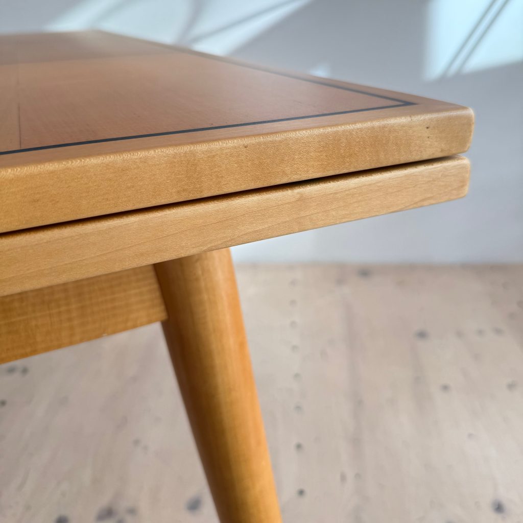 Close-up of a wooden table edge showcasing a smooth finish and elegant design.