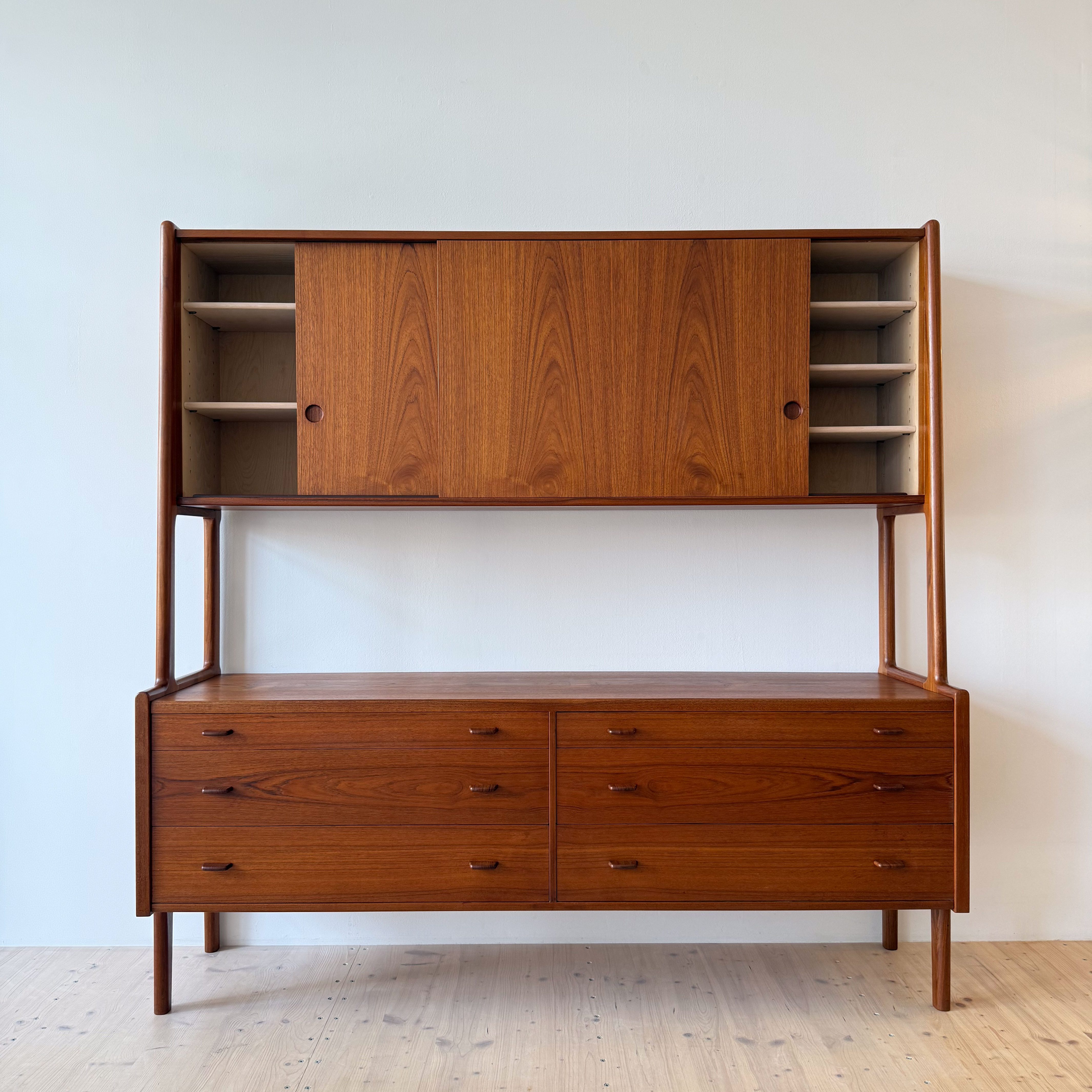 A mid-century modern wooden cabinet with a combination of open and closed storage spaces, featuring a rich wood finish and sleek lines.