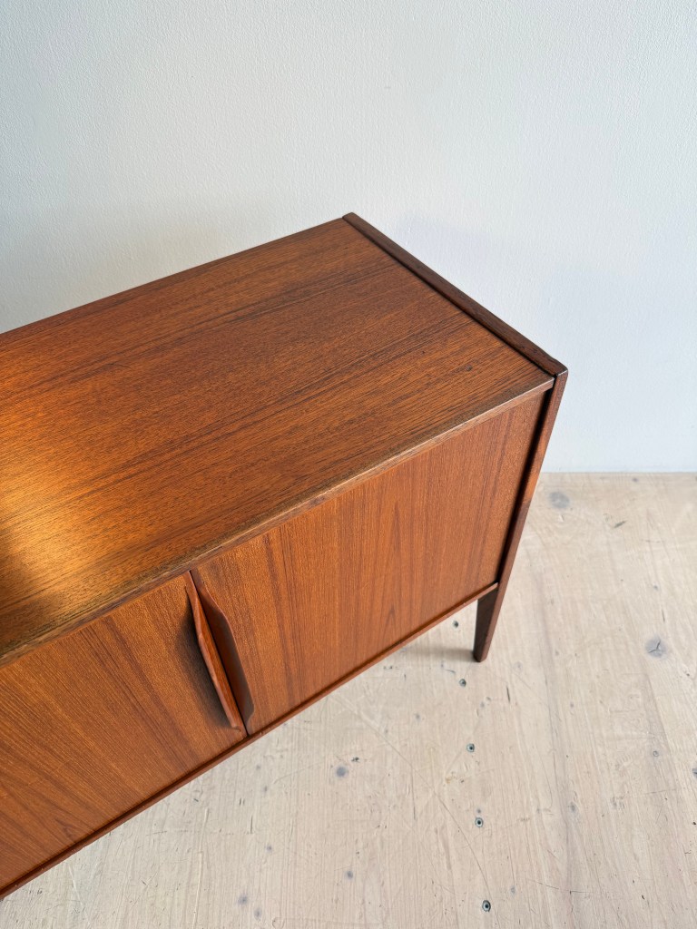 Top view of a wooden sideboard with two cabinet doors and a smooth surface, placed on a light wooden floor.
