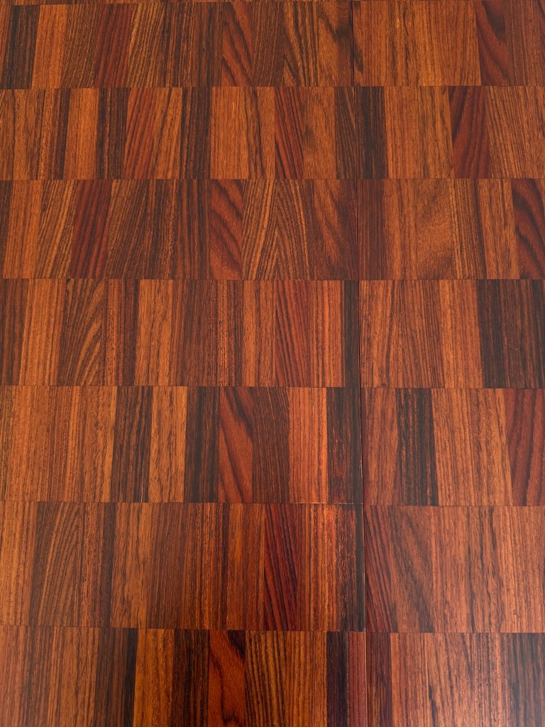 A close-up view of a patterned wooden floor with alternating dark and light brown square tiles, showcasing a rich texture and natural wood grain.