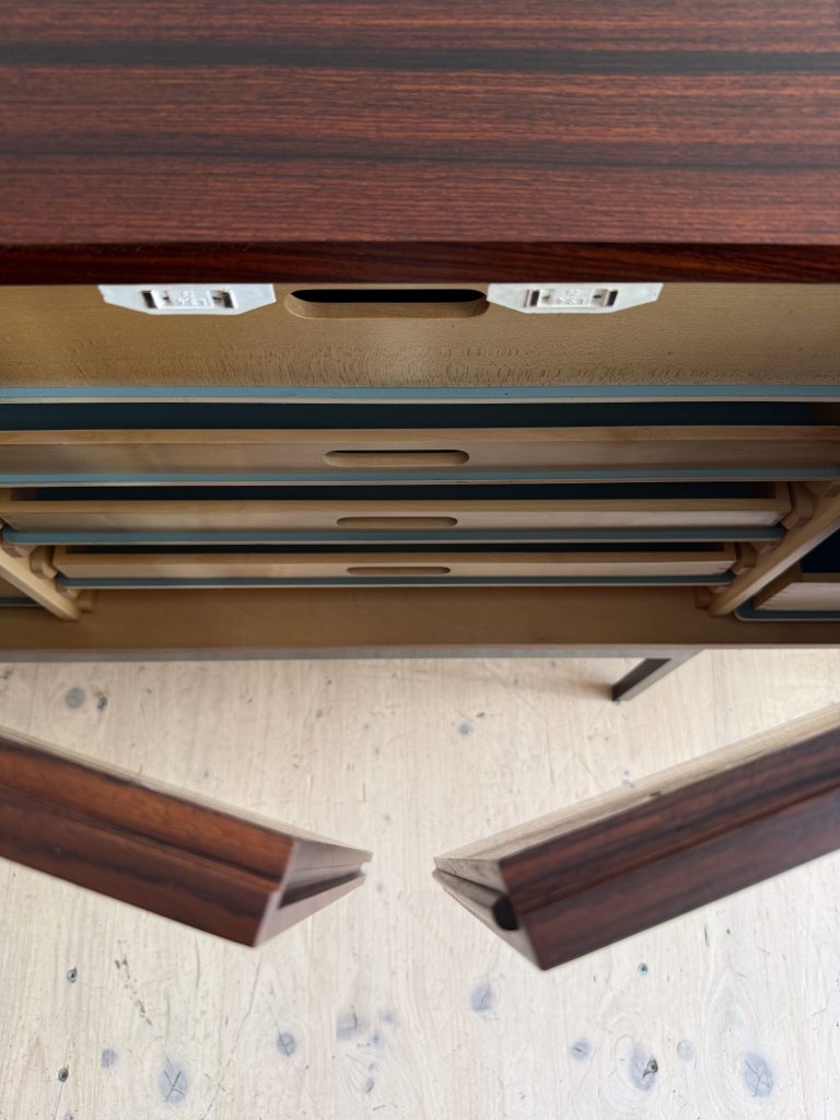 Top view of a wooden dresser with open drawers, showcasing a rich wood grain finish.