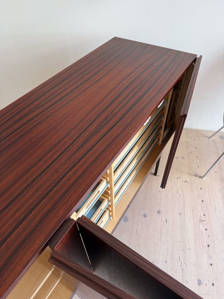 Top view of a wooden cabinet with a polished brown surface and an open drawer, showcasing a modern design.