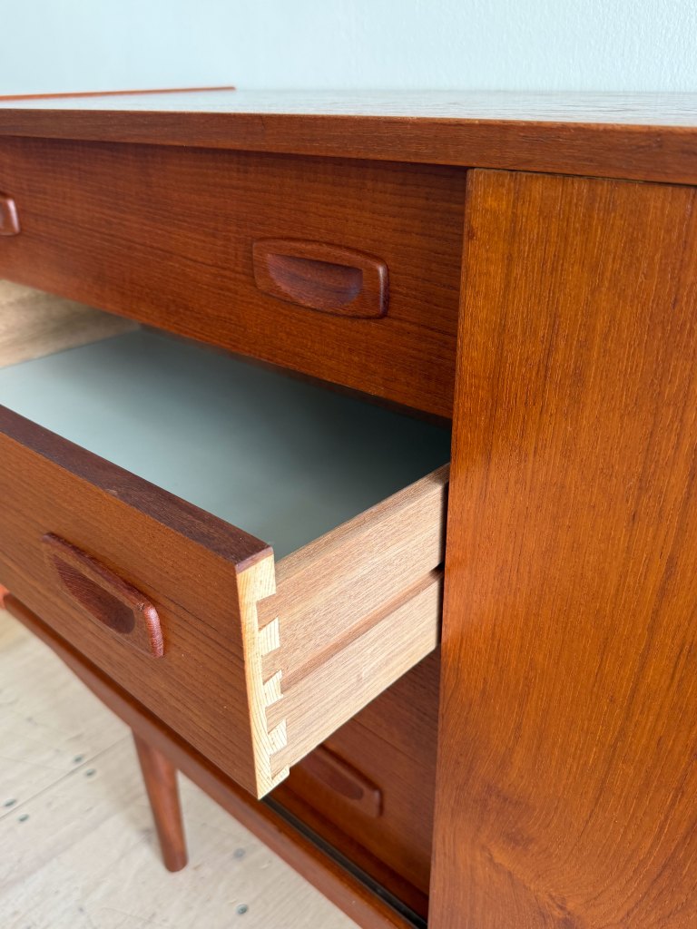 Close-up of a wooden drawer partially open, showcasing its smooth finish and dove-tail joint construction.
