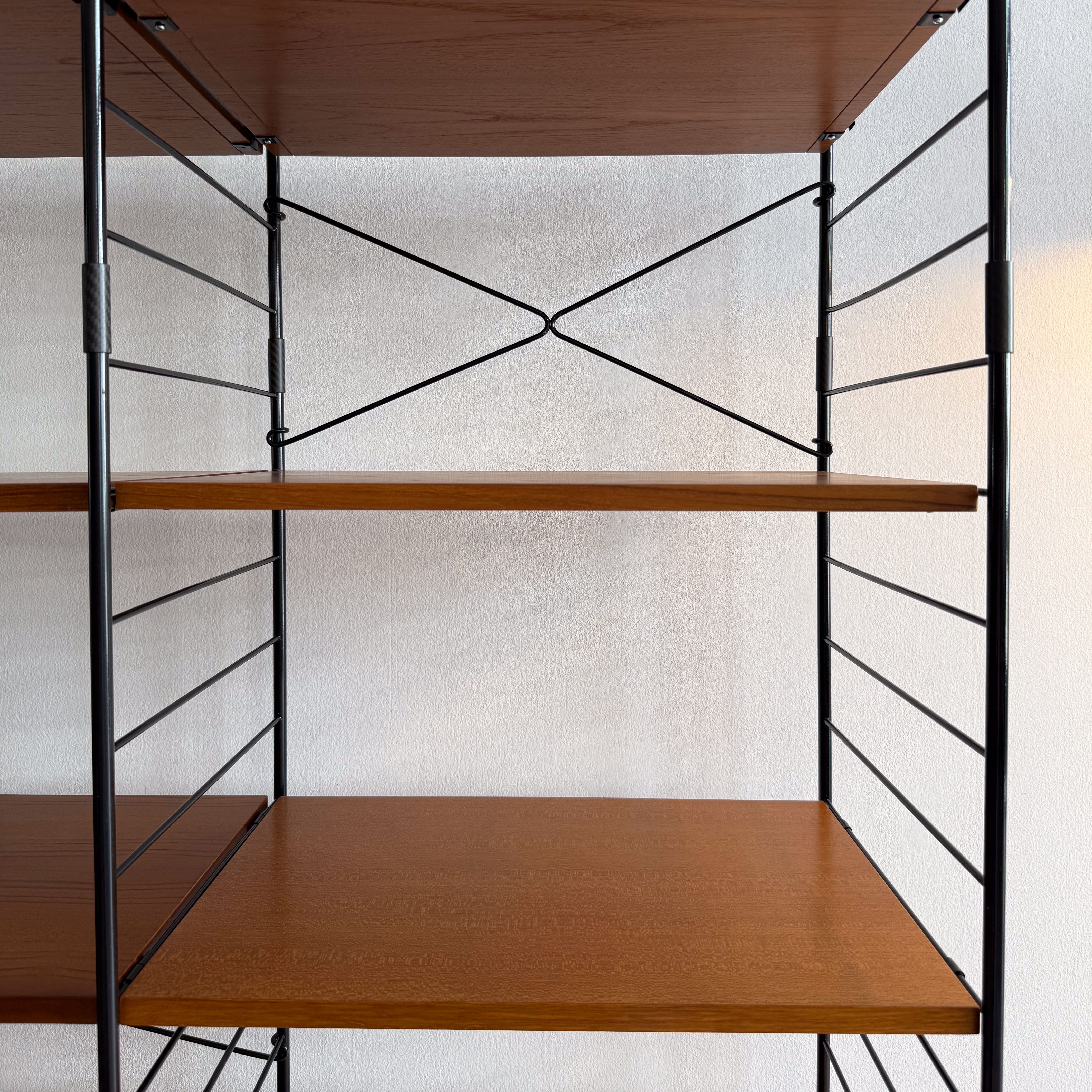 Close-up of a modern shelving unit with wooden shelves and black metal frame.