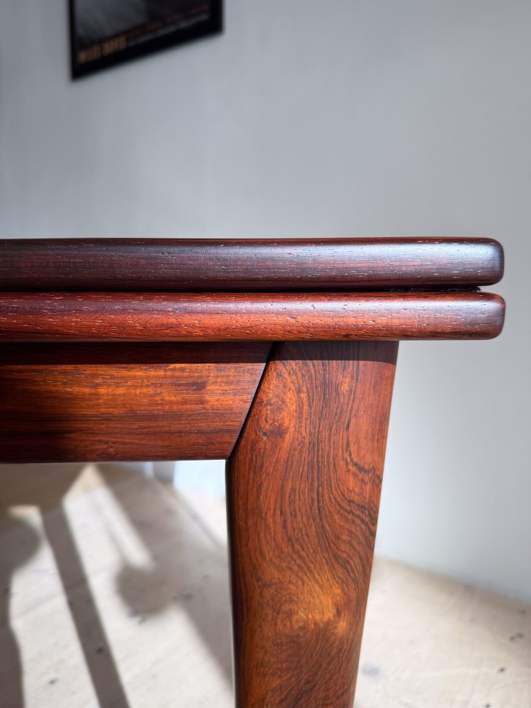Close-up of a wooden table edge highlighting its polished surface and grain pattern.
